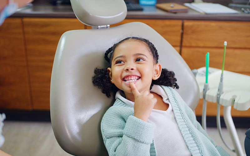 A smiling child in a dental chair