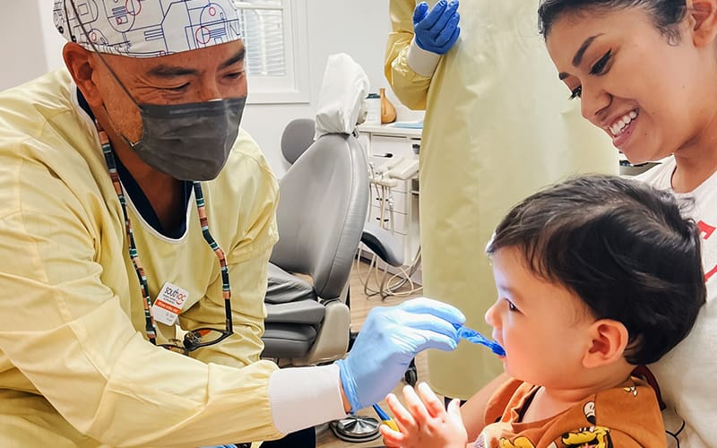 Dr. Sam Wu doing a pediatric exam on a young child