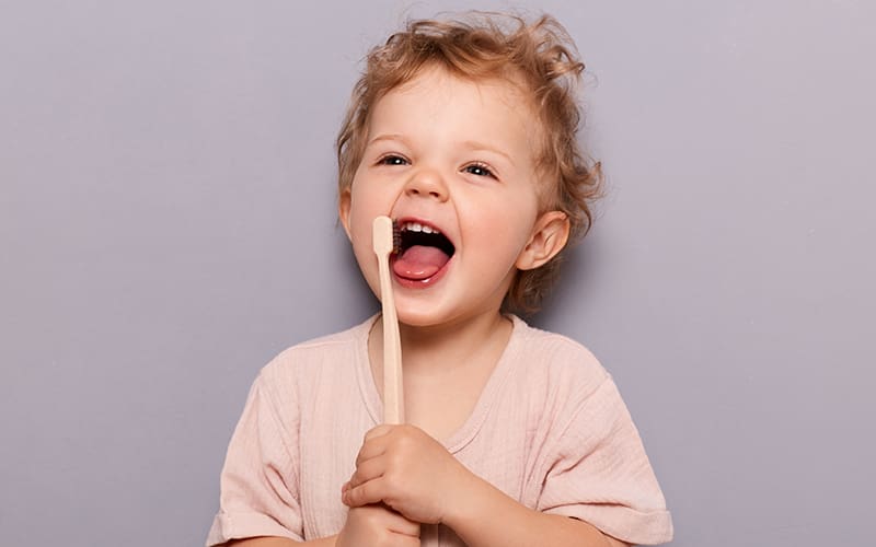 A toddler holding a tooth brush