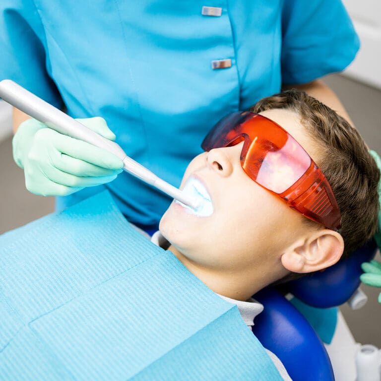 Young boy having fillings set with UV light
