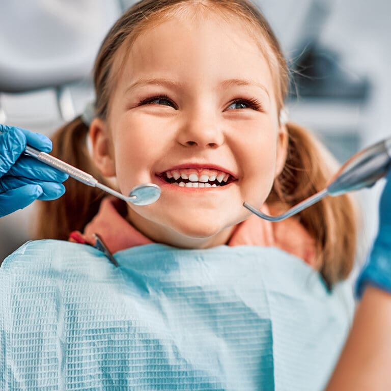 Young girl smiling in dentist chair