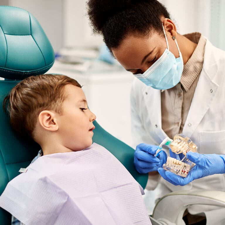 Dentist showing a boy with special needs a 3D model of a mouth